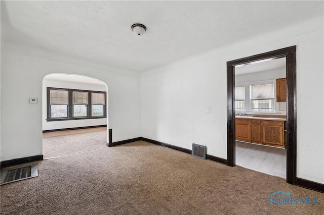 1908 Parkdale Ave, Toledo, OH 43607 - empty room featuring carpet floors, arched walkways, and baseboards