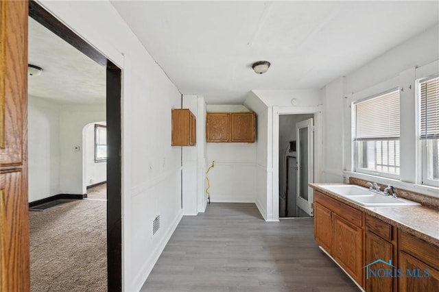 1908 Parkdale Ave, Toledo, OH 43607 - kitchen featuring brown cabinetry, healthy amount of natural light, and wood finished floors