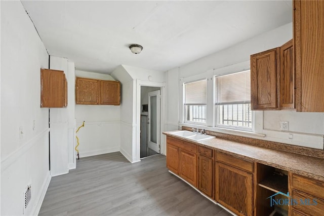 1908 Parkdale Ave, Toledo, OH 43607 - kitchen with a sink, brown cabinetry, light wood-type flooring, and baseboards