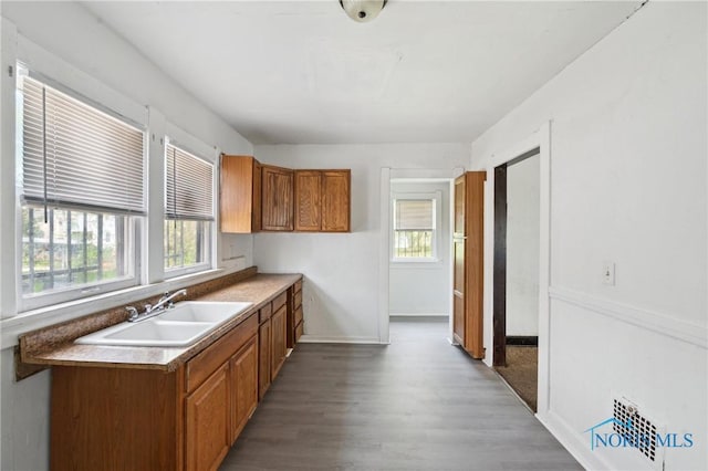 1908 Parkdale Ave, Toledo, OH 43607 - kitchen featuring a sink, brown cabinets, healthy amount of natural light, and wood finished floors