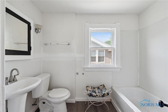 1908 Parkdale Ave, Toledo, OH 43607 - bathroom with a bathtub, a sink, toilet, and wood finished floors