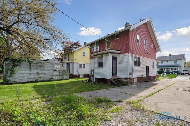 1908 Parkdale Ave, Toledo, OH 43607 - back of property featuring entry steps, a chimney, and a lawn