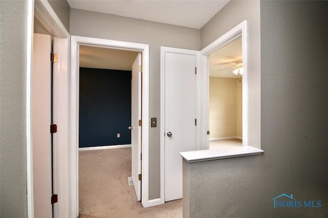 hallway with carpet floors and baseboards
