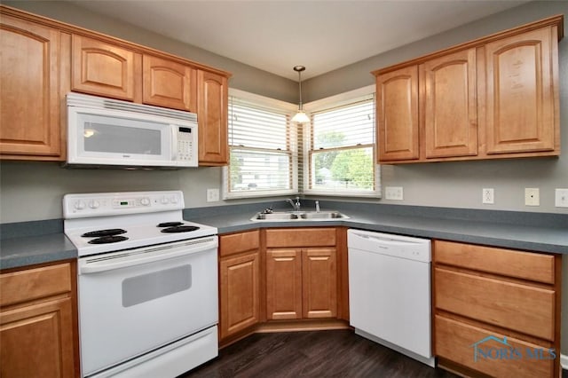 kitchen with white appliances, a sink, dark wood-style flooring, and dark countertops