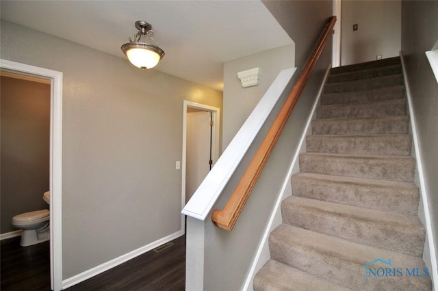 stairs featuring wood finished floors and baseboards