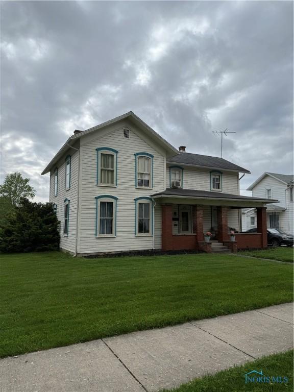 318 S Main St, North Baltimore, OH 45872 - view of front of property with covered porch and a front lawn