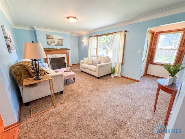 624 Myers St, Toledo, OH 43609 - living area with a fireplace, baseboards, light colored carpet, ornamental molding, and arched walkways