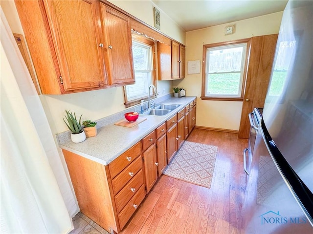 624 Myers St, Toledo, OH 43609 - kitchen featuring a sink, freestanding refrigerator, light wood finished floors, and light countertops