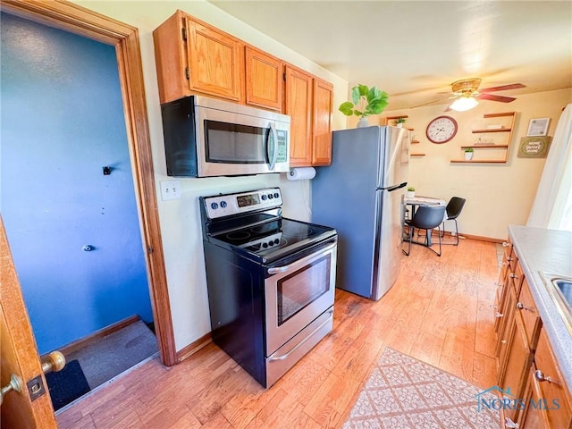 624 Myers St, Toledo, OH 43609 - kitchen with stainless steel appliances, light wood-type flooring, a ceiling fan, and baseboards