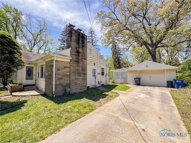 624 Myers St, Toledo, OH 43609 - view of side of property with a detached garage, a chimney, a lawn, an outdoor structure, and entry steps