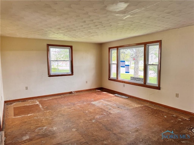 unfurnished room with baseboards
