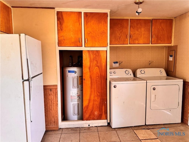 laundry area featuring water heater, washing machine and dryer, and light tile patterned floors
