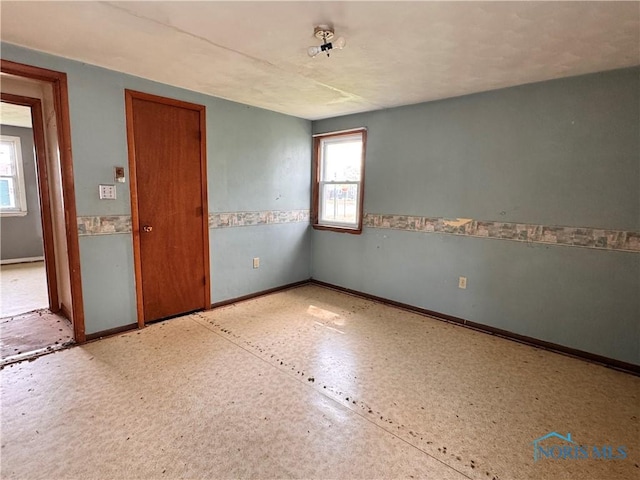 unfurnished room featuring baseboards