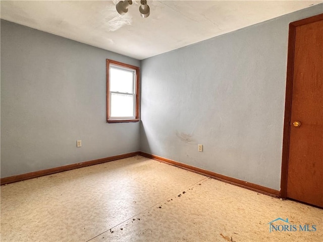 spare room with baseboards