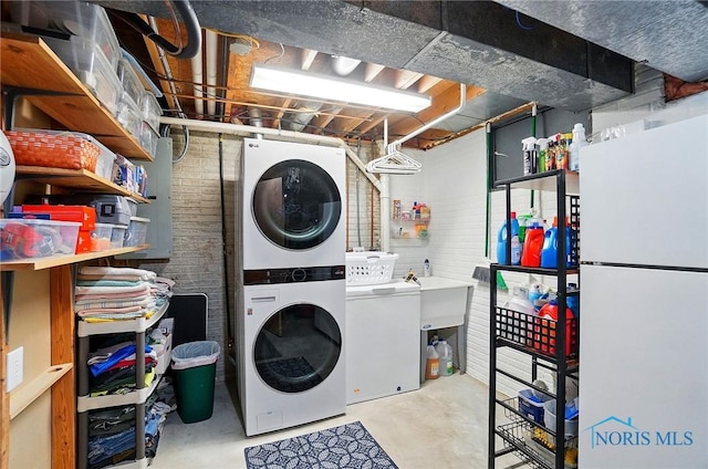 5532 Bentwood Dr, Toledo, OH 43615 - laundry room with stacked washer and clothes dryer and brick wall