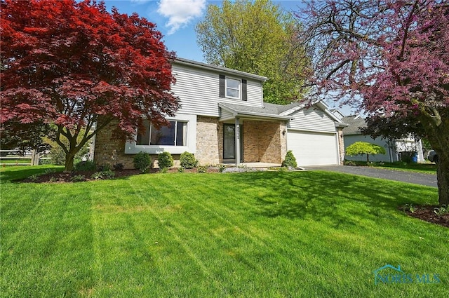 5532 Bentwood Dr, Toledo, OH 43615 - view of front of property featuring brick siding, asphalt driveway, a front lawn, and a garage