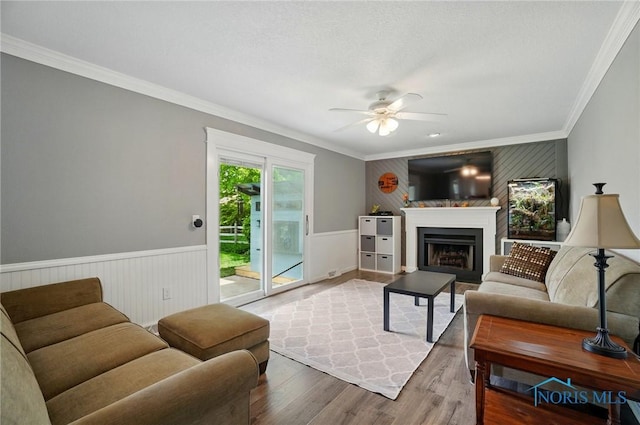 5532 Bentwood Dr, Toledo, OH 43615 - living area with ornamental molding, wood finished floors, ceiling fan, a fireplace, and a wainscoted wall