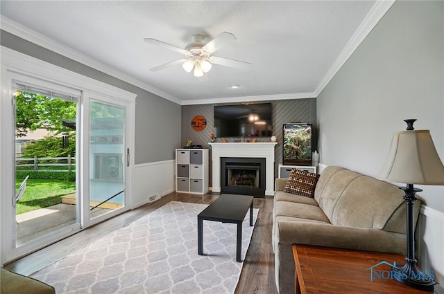 5532 Bentwood Dr, Toledo, OH 43615 - living room featuring wood finished floors, crown molding, ceiling fan, a fireplace with flush hearth, and an accent wall