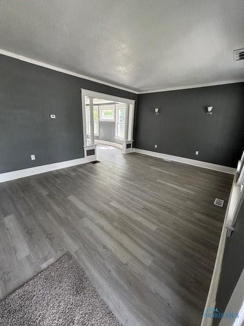 938 Western Ave, Toledo, OH 43609 - unfurnished living room with wood finished floors, baseboards, and crown molding