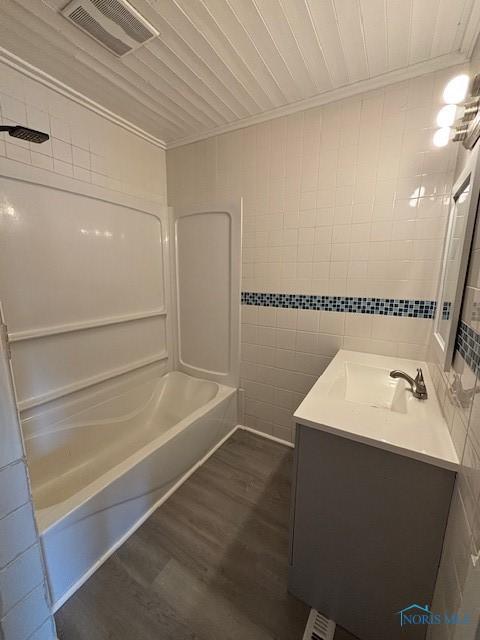 938 Western Ave, Toledo, OH 43609 - full bath featuring tile walls, vanity, wood finished floors, ornamental molding, and shower / bath combination