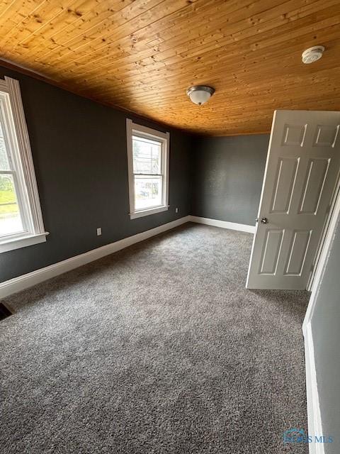 938 Western Ave, Toledo, OH 43609 - unfurnished room featuring wood ceiling, carpet floors, and baseboards