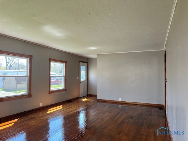 64 Saint Clair St, Tiffin, OH 44883 - empty room featuring hardwood / wood-style floors, baseboards, a textured ceiling, and crown molding