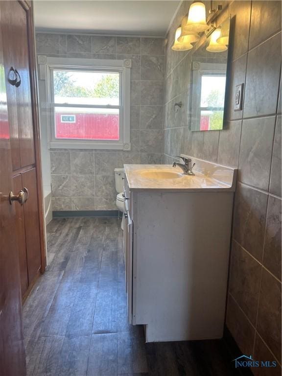 64 Saint Clair St, Tiffin, OH 44883 - bathroom featuring hardwood / wood-style floors, plenty of natural light, vanity, tile walls, and toilet