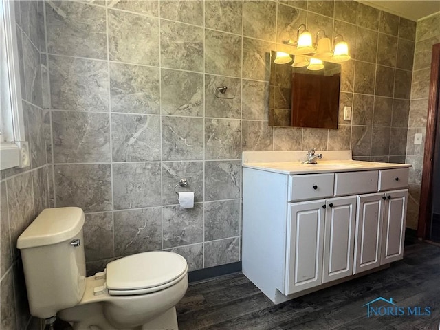 64 Saint Clair St, Tiffin, OH 44883 - bathroom with tile walls, wood finished floors, toilet, and vanity