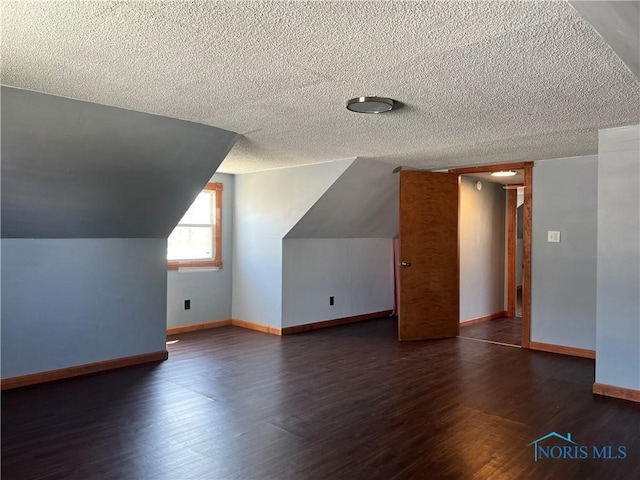 64 Saint Clair St, Tiffin, OH 44883 - additional living space featuring wood finished floors, a textured ceiling, baseboards, and lofted ceiling