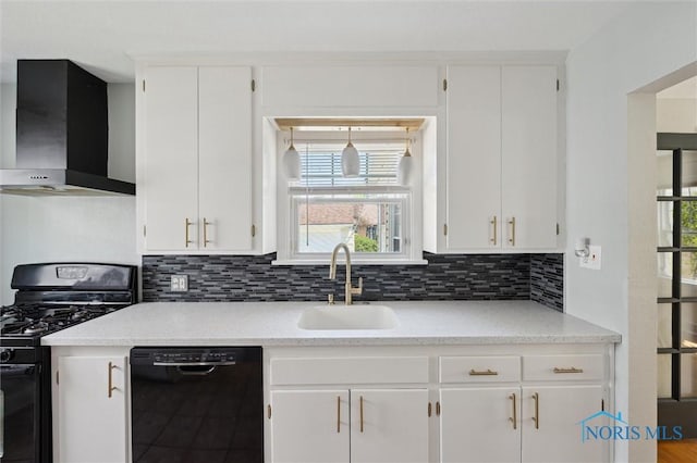 kitchen featuring black appliances, wall chimney range hood, a sink, and white cabinetry
