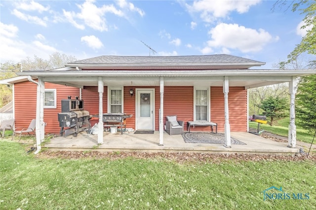 1037 Stevenson St, Napoleon, OH 43545 - rear view of house with a shingled roof, a porch, and a yard