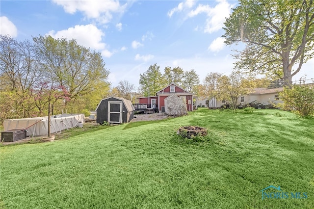 1037 Stevenson St, Napoleon, OH 43545 - view of green lawn featuring a shed, an outdoor fire pit, and an outbuilding
