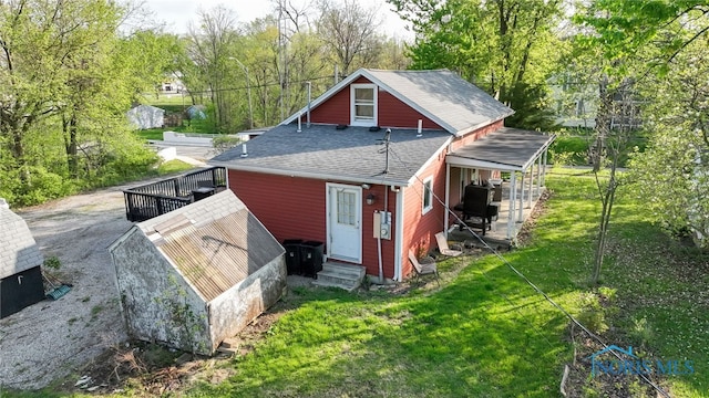 1037 Stevenson St, Napoleon, OH 43545 - rear view of house with entry steps, roof with shingles, and a lawn