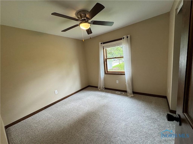 empty room with light carpet, a ceiling fan, and baseboards