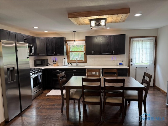 kitchen with stainless steel appliances, a sink, recessed lighting, light countertops, and backsplash