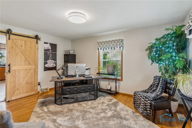 9704 Monto Ln, Findlay, OH 45840 - home office with a barn door, light wood-style floors, and baseboards
