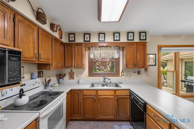2659 Coveview Dr, Toledo, OH 43611 - kitchen with black appliances, a sink, brown cabinetry, light countertops, and a textured ceiling