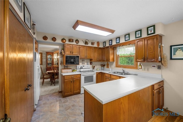 2659 Coveview Dr, Toledo, OH 43611 - kitchen with electric stove, black microwave, a sink, a peninsula, and brown cabinetry