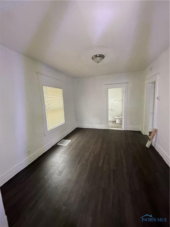 1821 Ridgewood Ave, Toledo, OH 43608 - spare room featuring baseboards and dark wood-type flooring