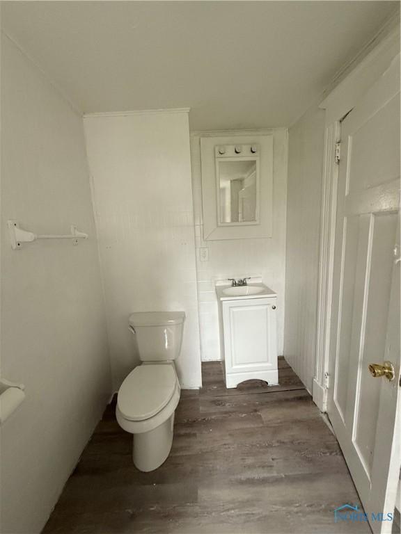 1821 Ridgewood Ave, Toledo, OH 43608 - half bathroom featuring wood finished floors, toilet, and vanity