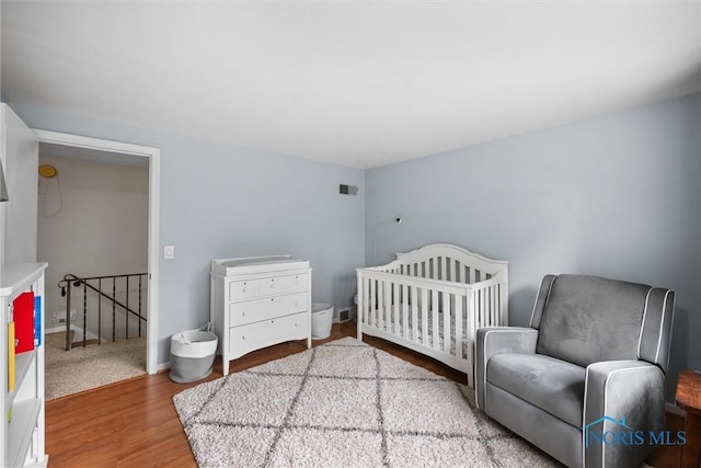 5511 Bent Oak Rd, Sylvania, OH 43560 - bedroom with wood finished floors, a nursery area, and baseboards