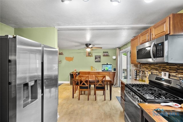 2034 Kellerston Rd, Maumee, OH 43537 - kitchen with appliances with stainless steel finishes, ceiling fan, decorative backsplash, light wood-type flooring, and brown cabinets