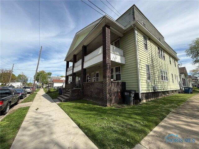 1202 Nevada St, Toledo, OH 43605 - view of side of property featuring a balcony and a yard