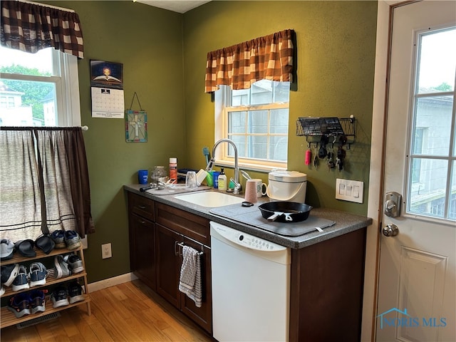 854 Maple Ave, Findlay, OH 45840 - kitchen featuring white dishwasher, light wood-type flooring, a sink, and healthy amount of natural light