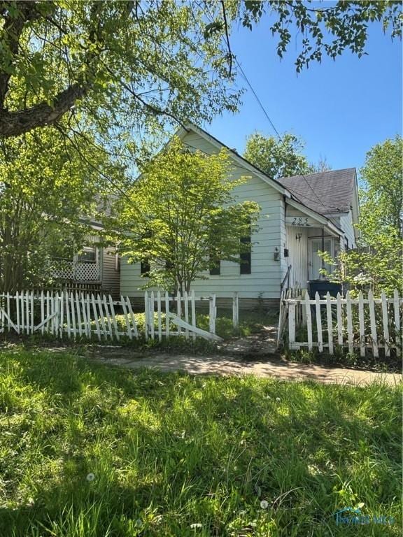 view of home's exterior featuring fence and a shingled roof