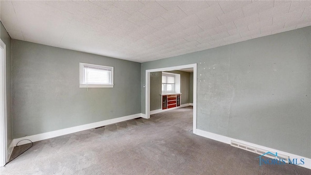 spare room with carpet flooring and baseboards