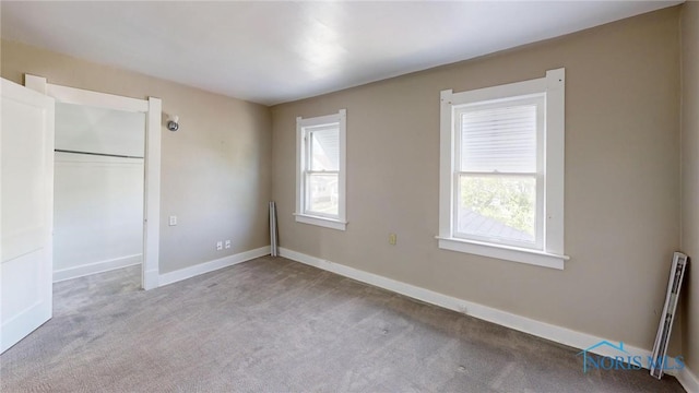 unfurnished bedroom featuring carpet flooring, baseboards, and a closet