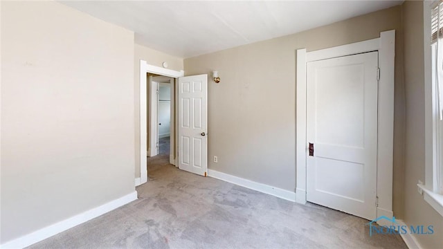 unfurnished bedroom with carpet, baseboards, and a closet