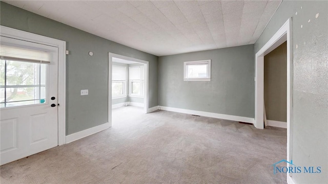 foyer featuring carpet flooring and baseboards