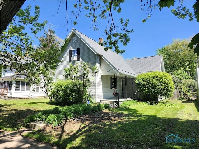 900 Leonard St, Fostoria, OH 44830 - view of side of property featuring a chimney, a lawn, covered porch, and roof with shingles